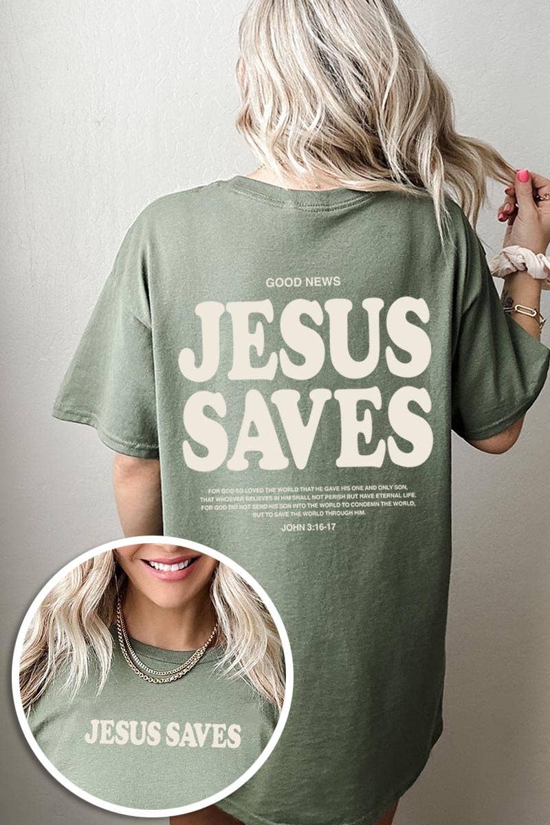 A woman with blonde hair is seen from behind wearing the COLORBEAR Jesus Saves Graphic Heavy Cotton Tee, an oversized green shirt featuring large “JESUS SAVES” lettering and the Bible reference John 3:16-17 on both the front and back.