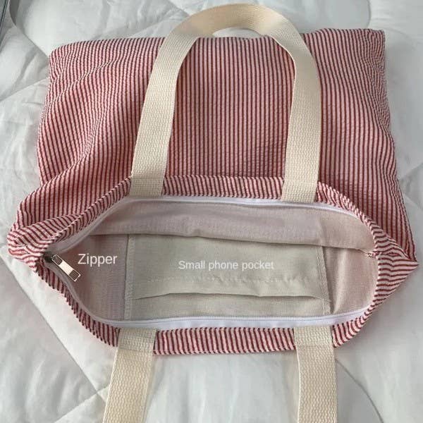 Open Large Red Stripe Shoulder Tote Bag by JOSSLYN by wall to wall showing a zippered main compartment and an interior pocket labeled Small phone pocket.