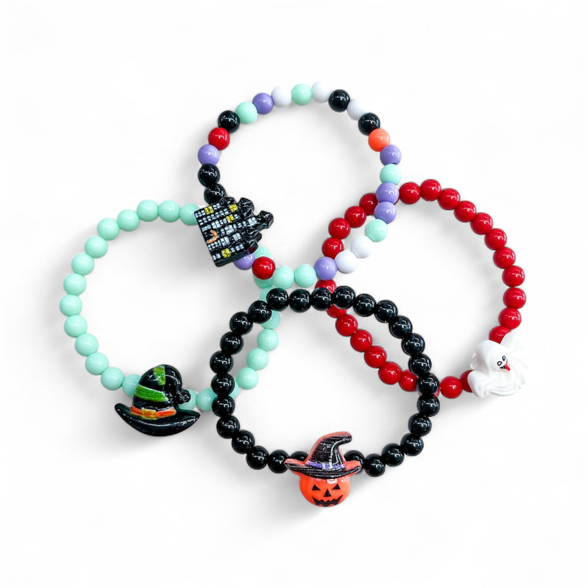 Four Spooky Bead Bracelet elastic bead bracelets featuring Halloween-themed charms, including a haunted house, a witchs hat, a ghost, and a jack-o-lantern.