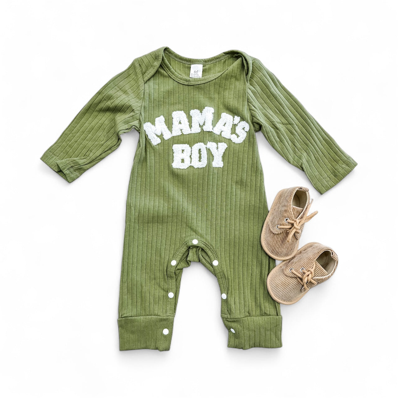 The Tiny Tot Bundles Newborn Mama's Boy Ribbed Romper in green features “MAMA’S BOY” in white across the chest, shown beside tan baby shoes on a white background.