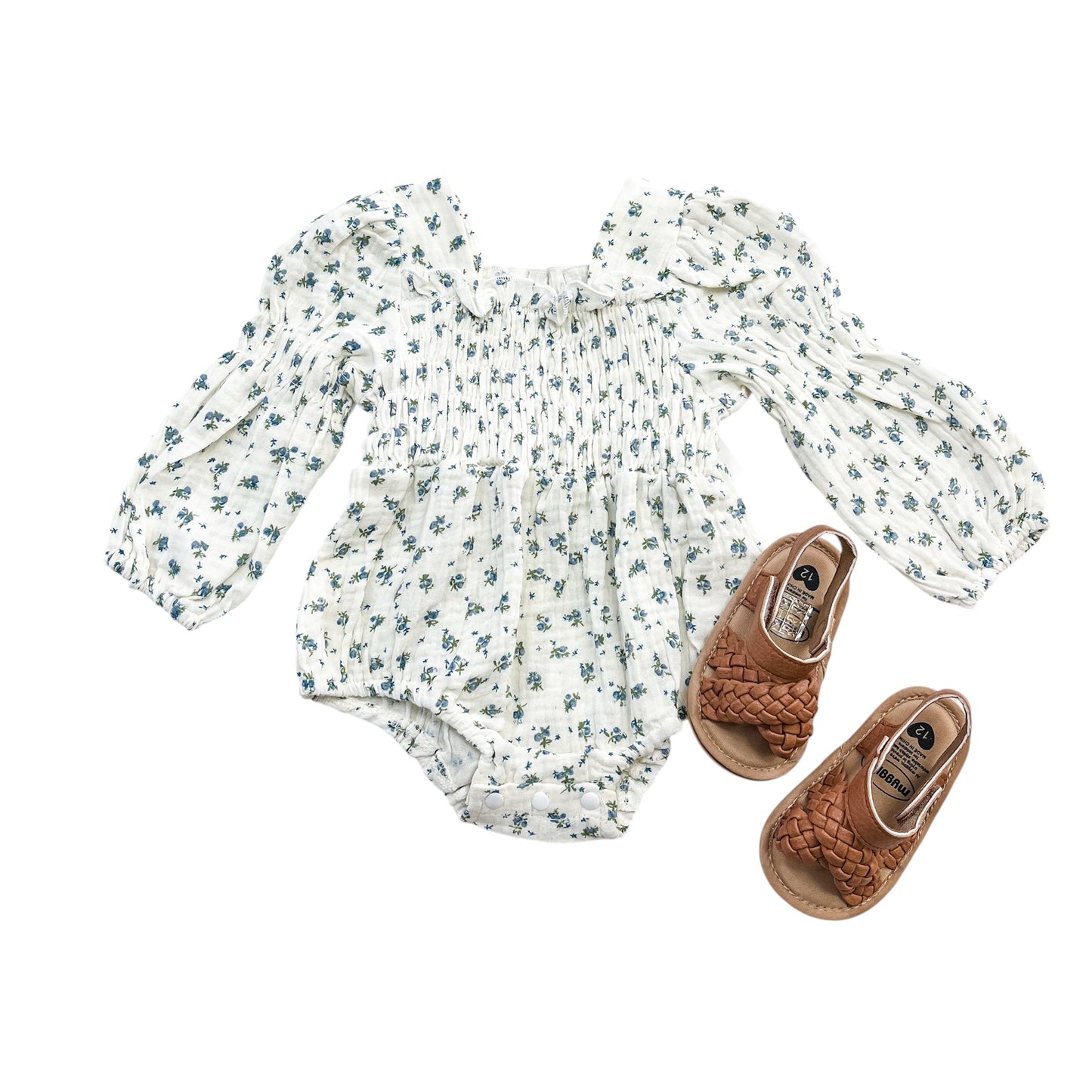 The Vintage Blue Scrunch Romper + Bow by Tiny Tot Bundles is displayed with brown woven baby sandals, all arranged neatly on a white background.