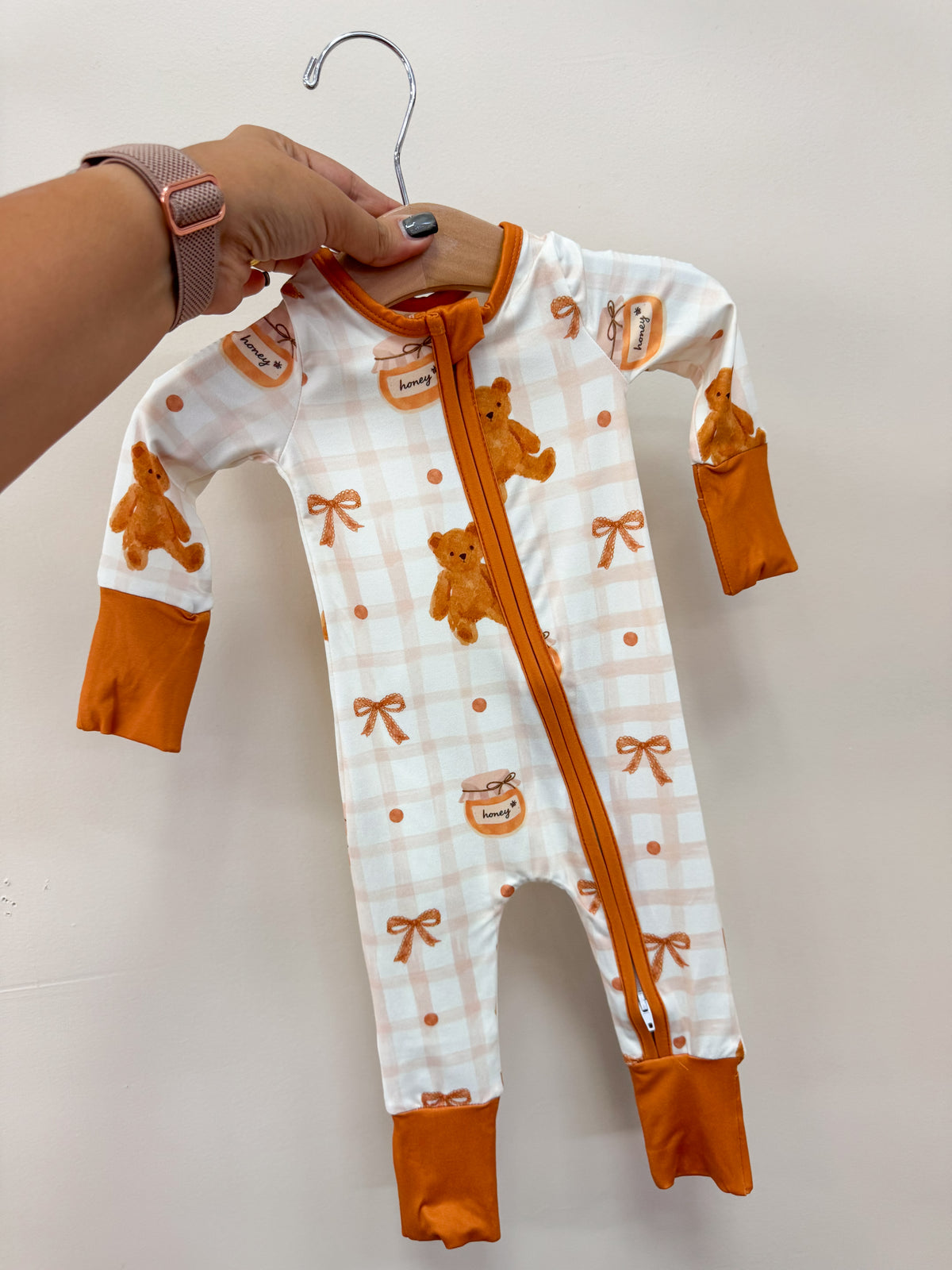 Tiny Tot Bundles Honey Pot Cuddles Zippy featuring a white and orange plaid pattern with teddy bears, honey jars, and bows, finished with solid orange cuffs and a front zipper.