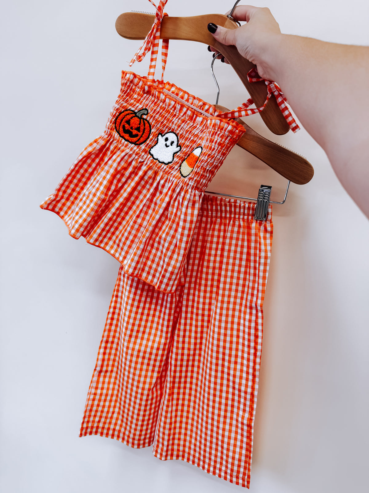 Tiny Tot Bundles Spooky Sweet Gingham Set featuring an orange and white two-piece outfit with embroidered pumpkin, ghost, and candy corn patches on the top.