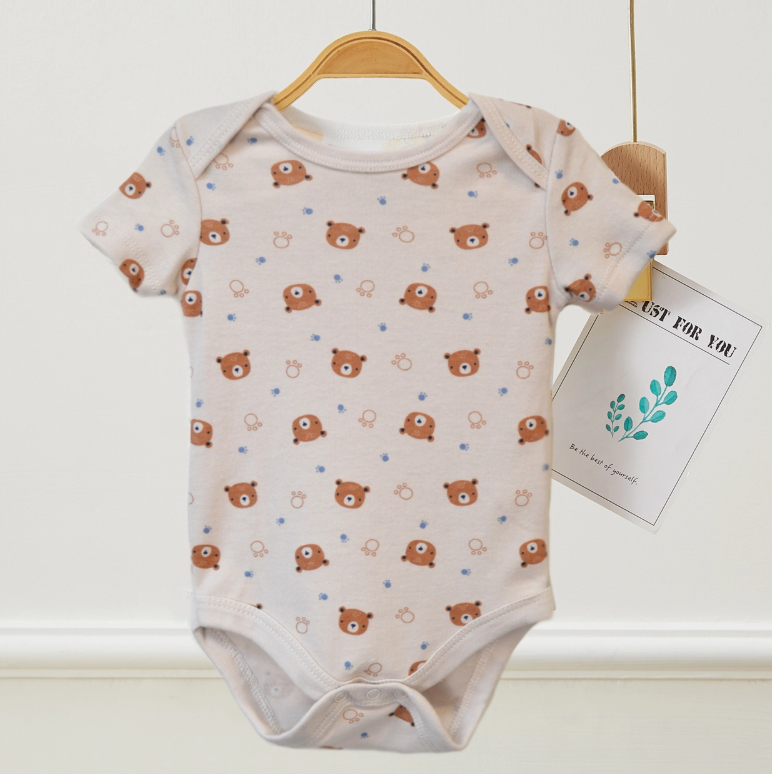 A light-colored Mommy Hugs Bubble Trio onesie by Lollipop Dreams, featuring small brown bear faces and blue rings, hangs on a wooden hanger with a card that reads JUST FOR YOU.