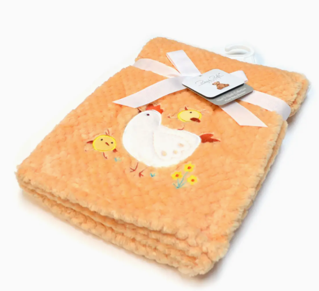 The Lollipop Dreams Little Chick Snuggle Blanket features soft orange fabric with embroidered ducks and flowers, folded neatly and tied with a white ribbon and tag—perfect for your baby’s cozy moments.