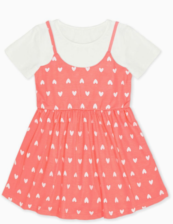 The Cutie Patootie "Peachy Hearts Layered Dress" features a short-sleeved white tee under a sleeveless coral pink dress with small white heart prints, a fitted waist, and flared skirt.