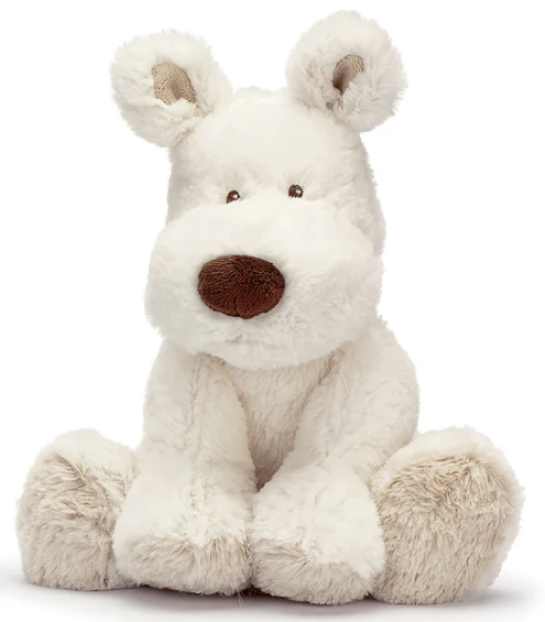 The Triaction Medium Teddy Cream Dog is a plush white stuffed animal with floppy ears, a round brown nose, and small black eyes, seated upright with legs extended in front.