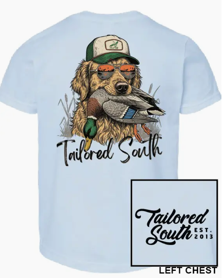The Lab Duck Head Youth T-shirt by Wild Trail Outfitters features a dog wearing a cap and sunglasses, holding a duck, with "Tailored South" below. The left chest has a small "Tailored South EST. 2013" logo.