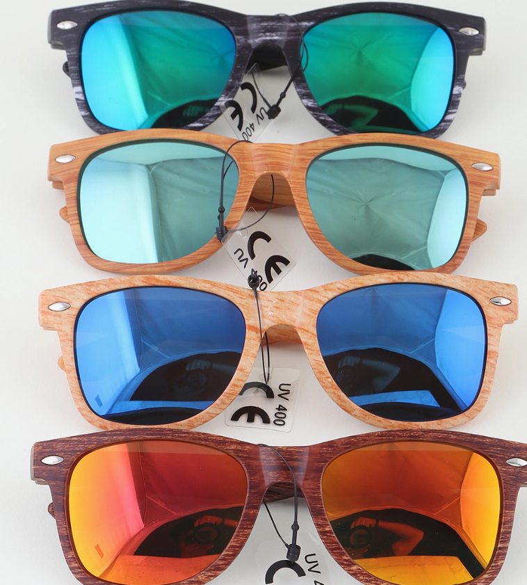 Five pairs of 3AM BY H&D ACCESSORIES Modern Streak Wayfarer Sunglasses with wood-style frames are stacked vertically. Lenses in green, light green, blue, dark blue, and orange-red reflect light; some feature UV protection tags.