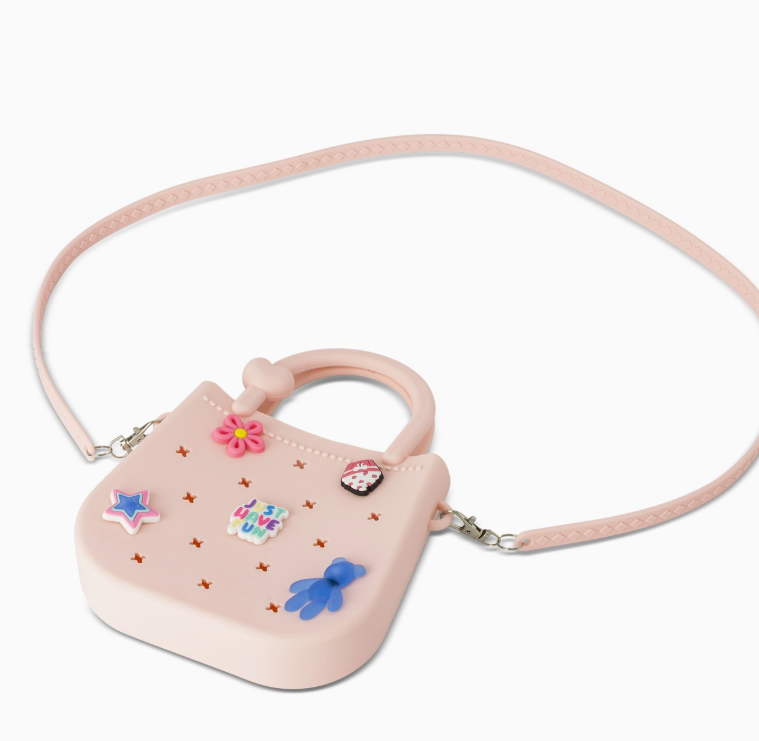 The core home Mini Round Eva Purse - Pink features a long strap, colorful star, flower, and heart charms with "NICE DAY" text, plus small star-shaped cutouts.