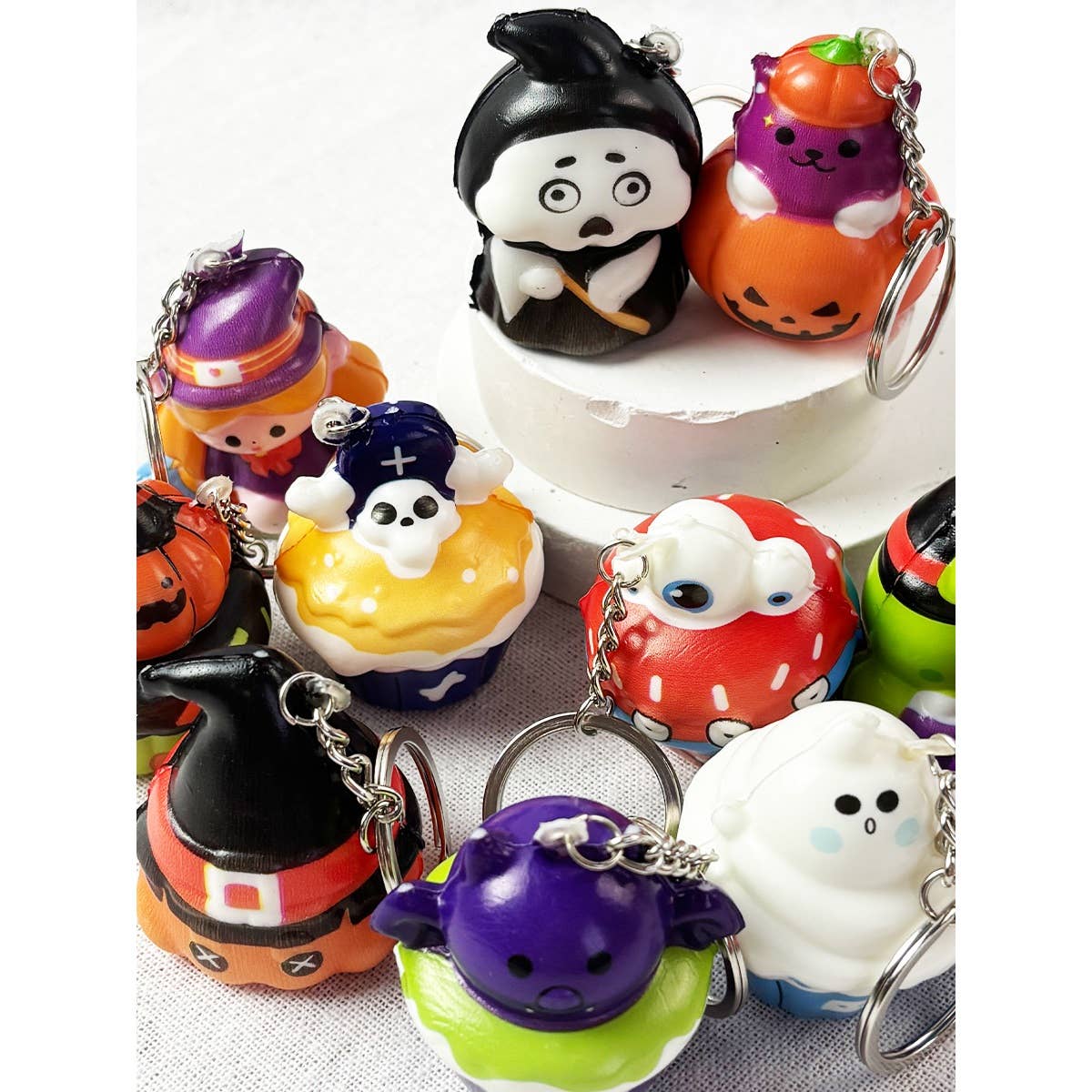 A collection of colorful Halloween Squishy Keychain designs, including ghosts, pumpkins, witches, and monsters.
