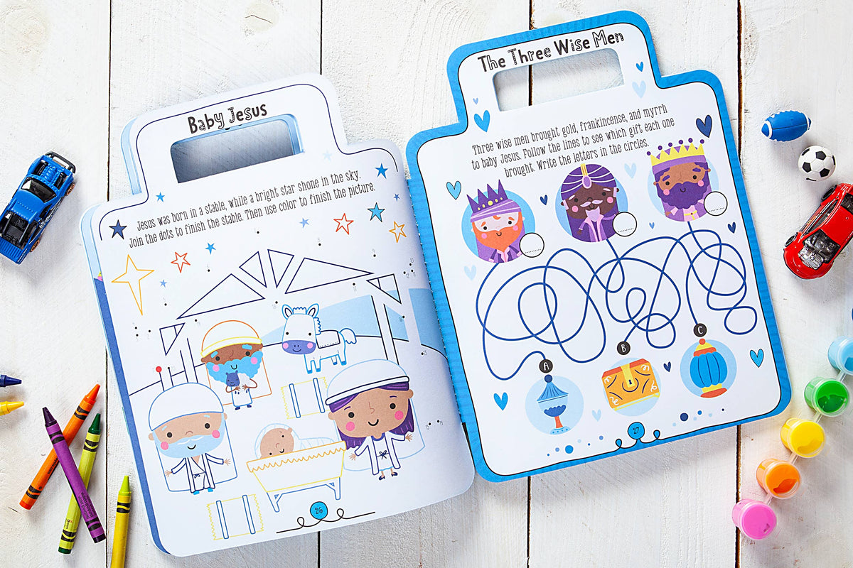 The My Bible Backpack Activity Book by BroadStreet Publishing Group, LLC is open to illustrated nativity and three wise men scenes with a maze activity, surrounded by crayons and toy cars on a white wooden table.