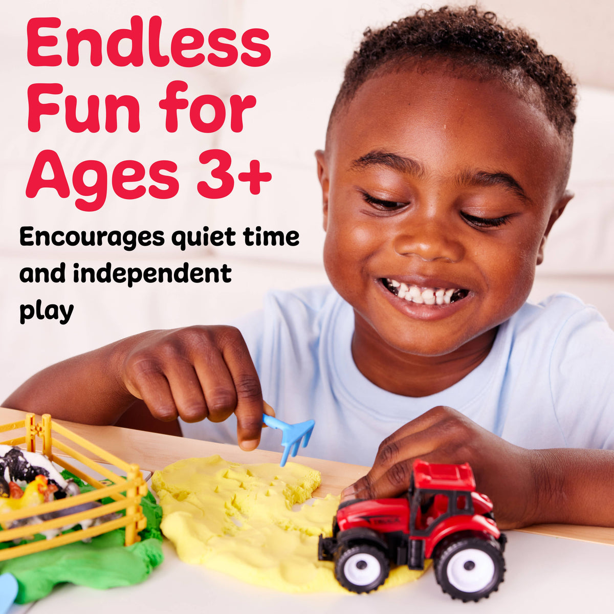 Smiling child playing with the Faber-Castell / Creativity for Kids Sensory Pack Farm On the Go Sensory Play Set on a yellow playmat, imagining farm adventures with toy tractors and animals. Text reads: Endless Fun for Ages 3+ Encourages quiet time and independent play.