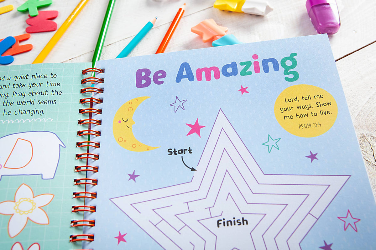 Childrens activity book page from the God Made Me Journal Book by BroadStreet Publishing Group, LLC features the phrase “Be Amazing” in colorful letters, a star maze, colored pencils, and erasers. A Bible verse in a yellow circle reads: “Lord, tell me your ways. Show me how to live. PSALM 25:4.”.