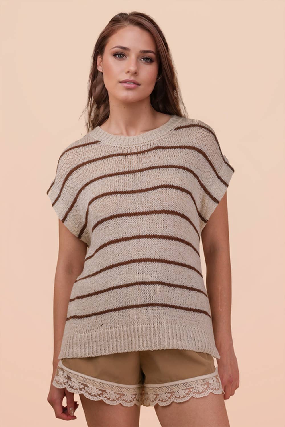 A person wearing a VERY J Striped Knit Sweater Vest Top in beige with brown horizontal stripes.