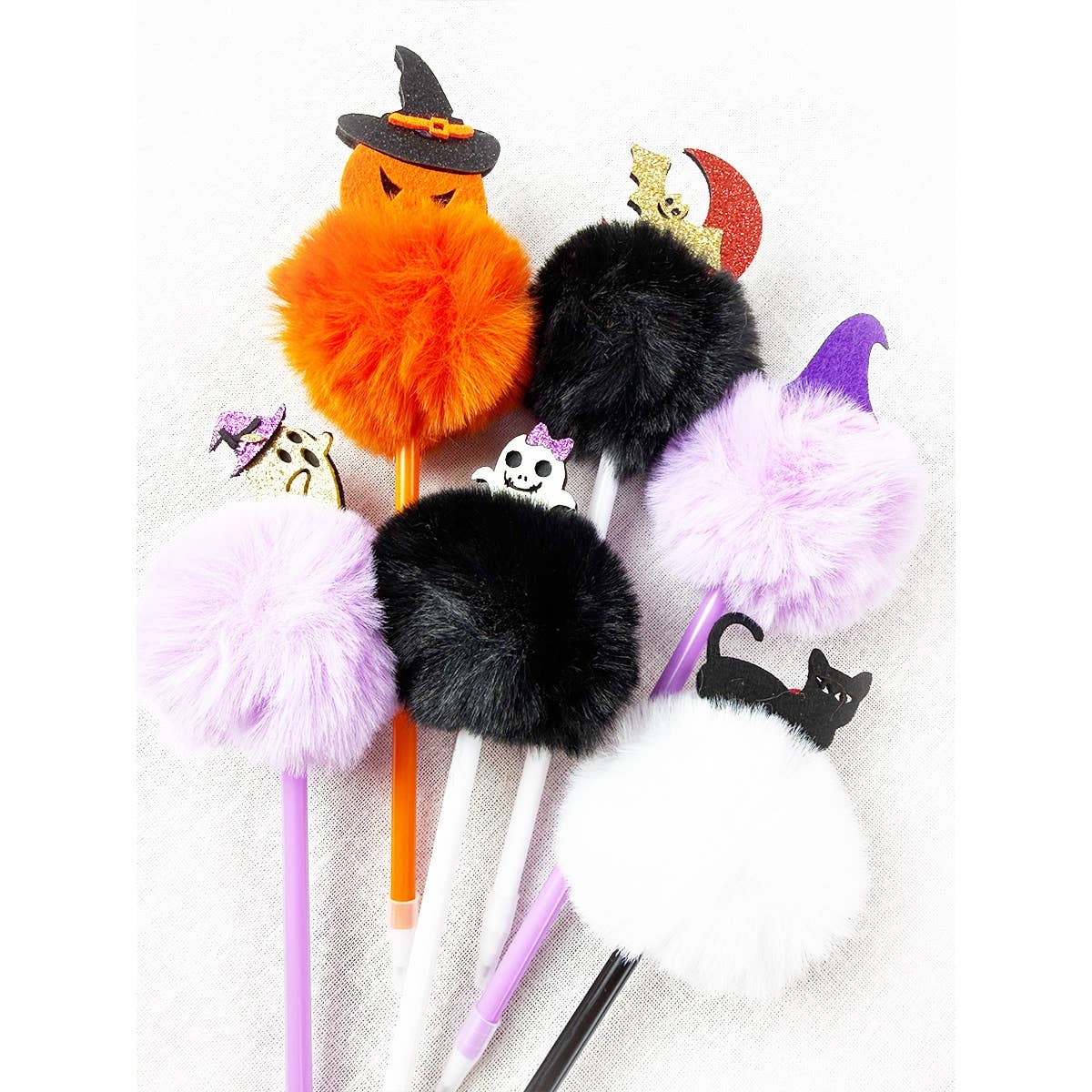 Six Halloween Theme PomPom Pen writing instruments topped with large colorful pom-poms and various Halloween-themed charms including a jack-o-lantern, ghost, crescent moon, and black cat.