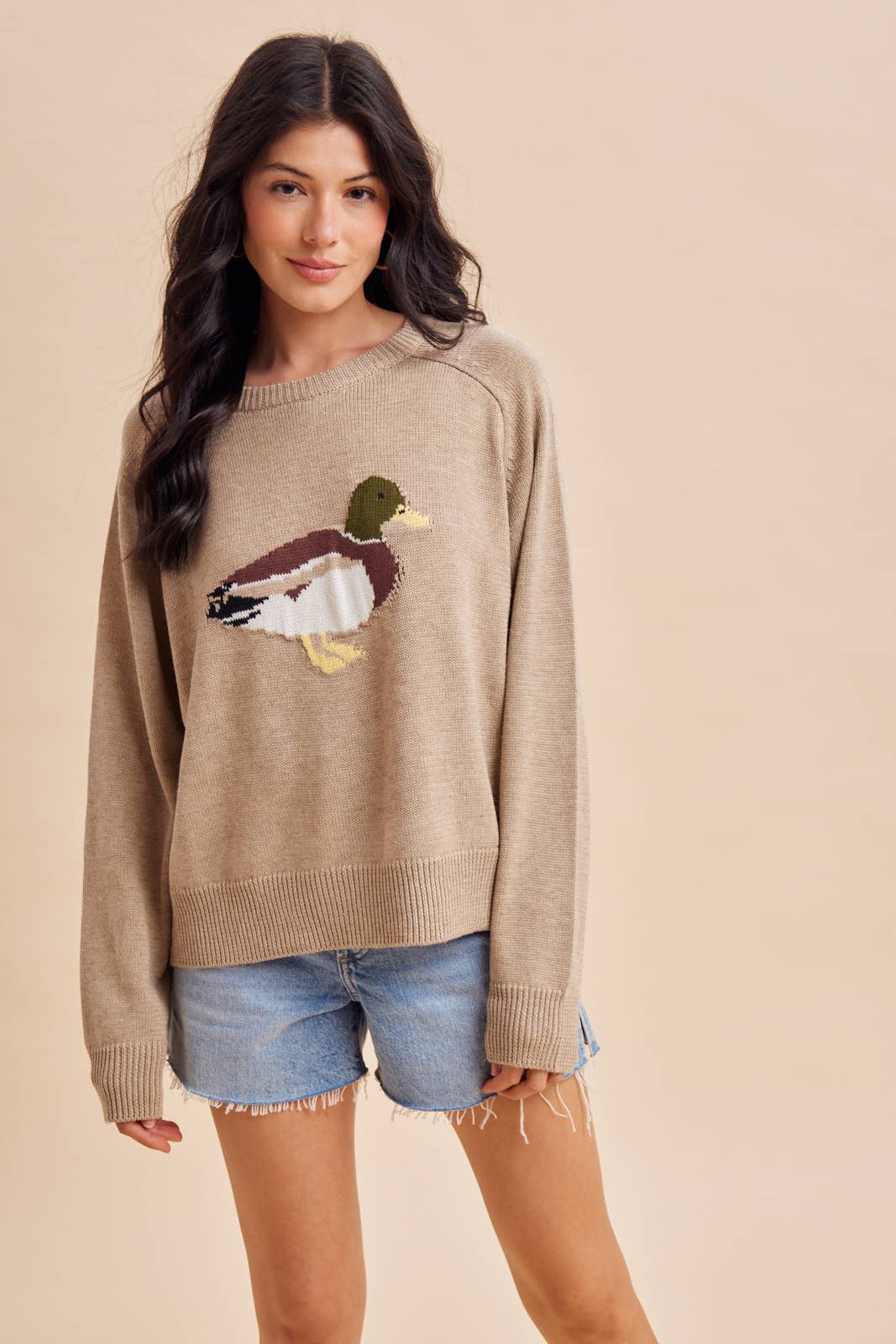 A beige long-sleeved In Loom Mallard Duck Knitted Sweater featuring a large knitted mallard duck design on the front.
