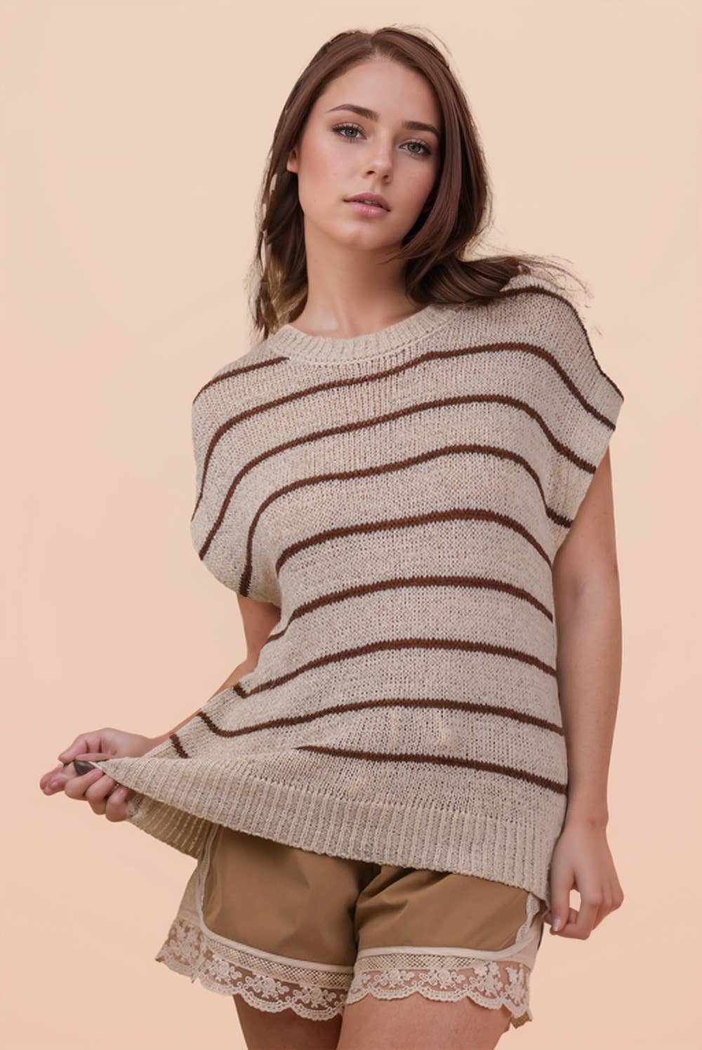 A woman wearing a VERY J Striped Knit Sweater Vest Top in tan with thin brown horizontal stripes.