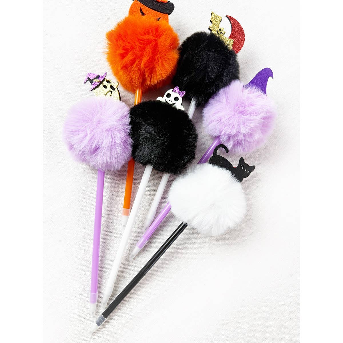 Five Love and Repeat Halloween Theme PomPom Pens topped with colorful fuzzy pom-poms and charms including a ghost, a pumpkin, a crescent moon, a skull, and a black cat.