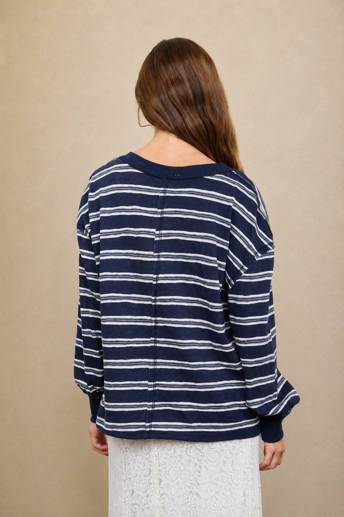 Back view of a person wearing a navy and white Blue Stripe V-Neck Long Sleeve with a vertical seam down the center back.