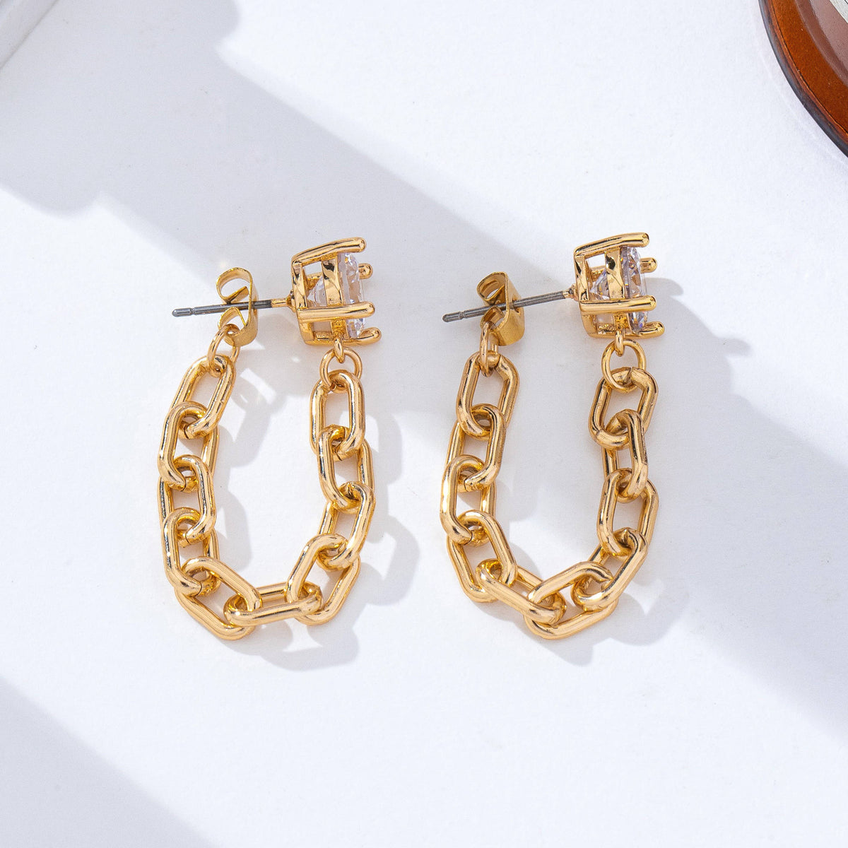 The JOSSLYN by wall to wall Stud Hoop and Drop Link Earrings are displayed on a white surface under natural light, featuring gold chain-link hoops with square gemstone studs.