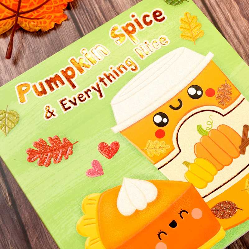 Close-up of the book cover for Pumpkin Spice & Everything Nice by Dienesa Le, published by Simon & Schuster, featuring adorable, smiling pumpkin spice drink and pie illustrations surrounded by sparkling autumn leaves and hearts on a light green background.