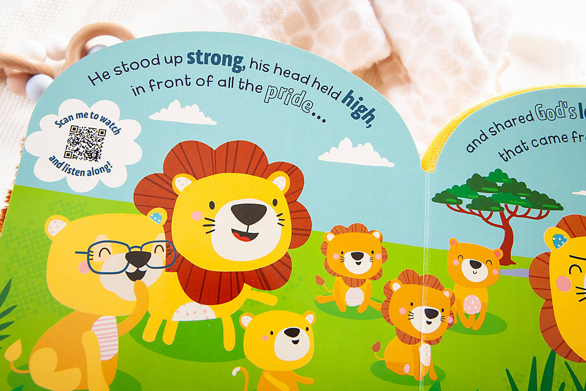 A page from the Squish and Snugg Lion Book by BroadStreet Publishing Group, LLC features a cheerful lion family standing together on the grass. The text highlights a lion confidently leading its pride, with a QR code displayed on the left page.