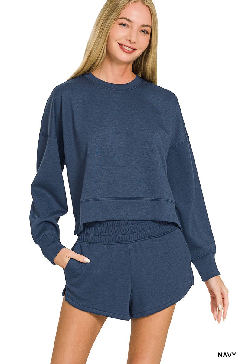 A model wearing a 42POPS Navy Scuba Top & Short Set consisting of a navy blue long-sleeved cropped top and matching shorts with an elastic waistband.