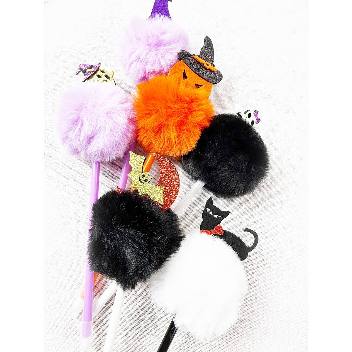 Five Halloween Theme PomPom Pen writing instruments topped with colorful fuzzy pom-poms and Halloween-themed charms, including a pumpkin, ghost, bat, cat, and witch hat.