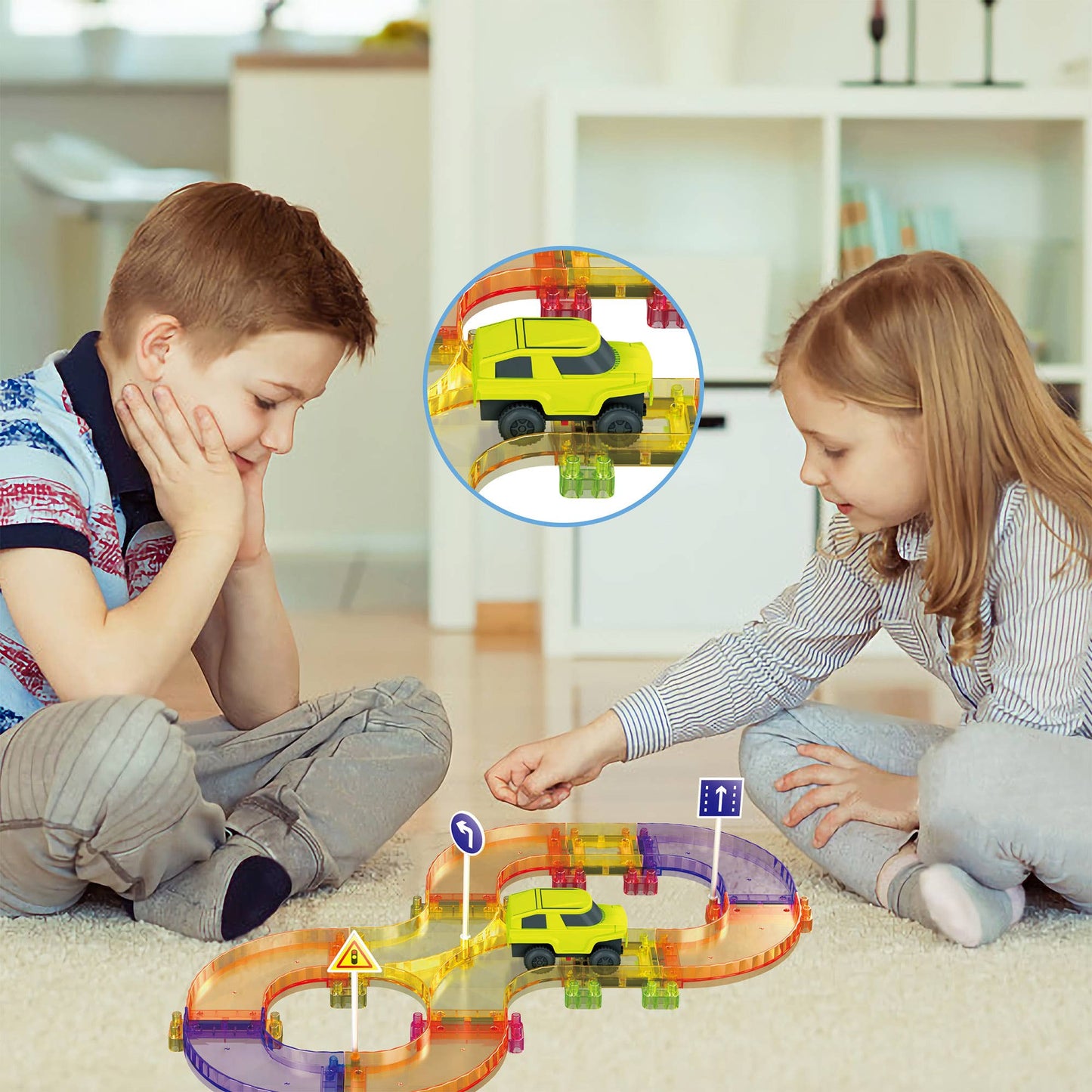 Two young children play on the floor with the PicassoTiles 40pc Travel Size Magnetic Tile Race Track Set. A close-up shows a yellow toy car on the track. PicassoTiles brand toys are in use, with furniture and shelves in the background.