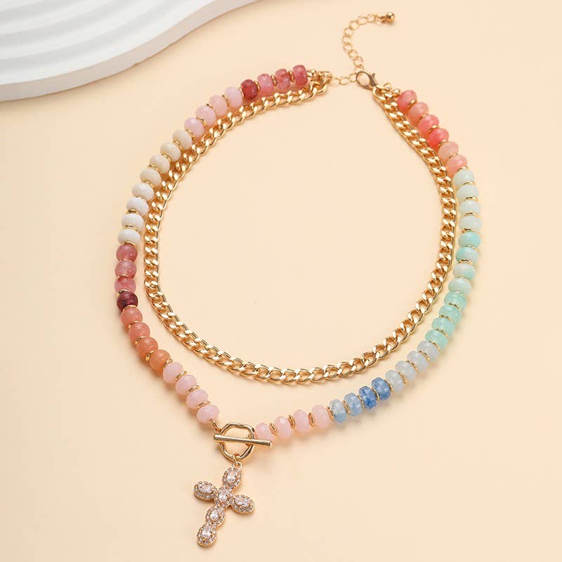 JOSSLYN by wall to wall’s Multi Layer Pendant Resin Beaded Necklace features pastel resin beads that fade from pink to blue, a gold chain, an adjustable clasp, and a sparkling cross pendant.