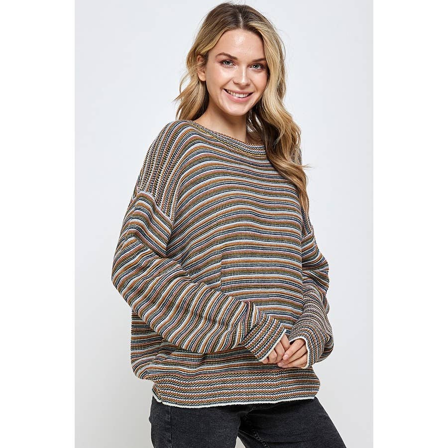 A woman smiles while wearing an oversized Multi Color Stripe Pullover Sweater featuring horizontal stripes in earth tones.