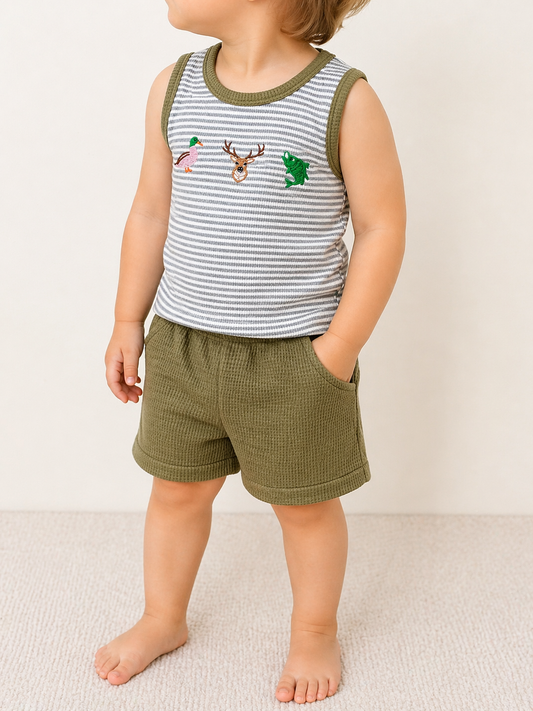 A child wears the Tiny Tot Bundles Woodland Adventure Tank Set: olive green shorts and a gray-and-white striped tank top with green trim and embroidered bird, deer head, and fish designs. The child's face is not visible.