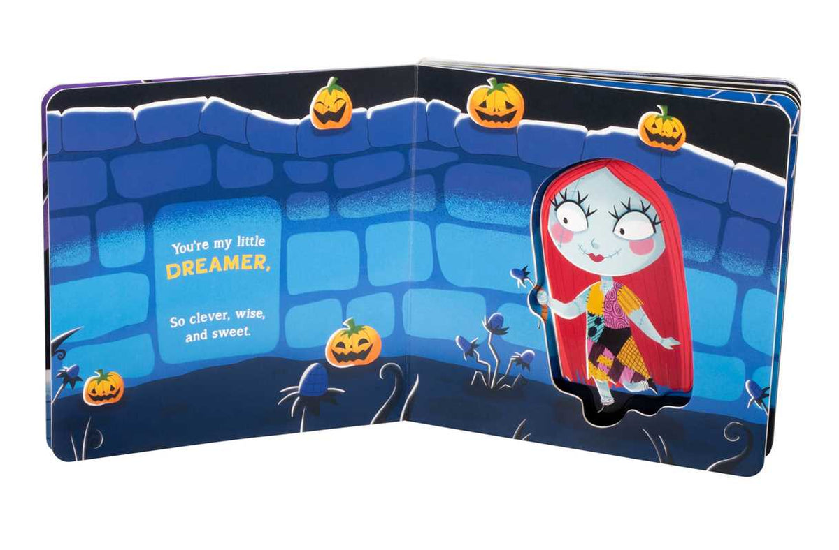An open copy of “You’re My Little Nightmare” by Grace Baranowski (Simon & Schuster) featuring a red-haired doll figure amid pumpkins and vines on the right page, with the left page reading: “You’re my little DREAMER, So clever, wise, and sweet,” against a blue stone wall background.