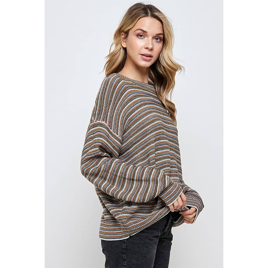 A woman wears a Sweet Generis Multi Color Stripe Pullover Sweater, a long-sleeved, ribbed pullover featuring thin multicolored horizontal stripes in earth tones.