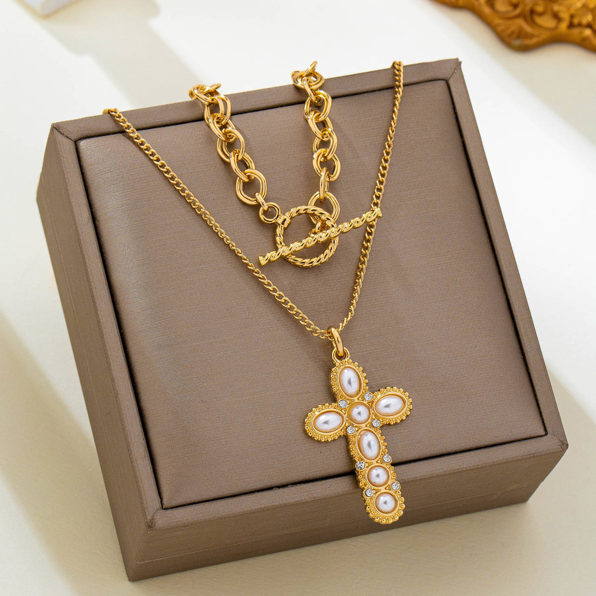 JOSSLYN by wall to wall Pearl Cross Layered Necklace Set featuring two gold-tone necklaces, one with a toggle clasp and one with an ornate cross pendant set with pearls and clear stones.