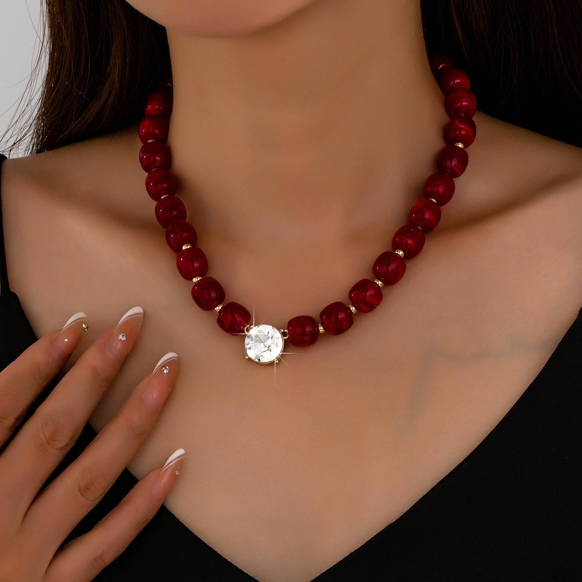 A JOSSLYN by wall to wall Resin Bead Round Crystal Pendant Necklace featuring a string of dark red beads and a central round crystal pendant.