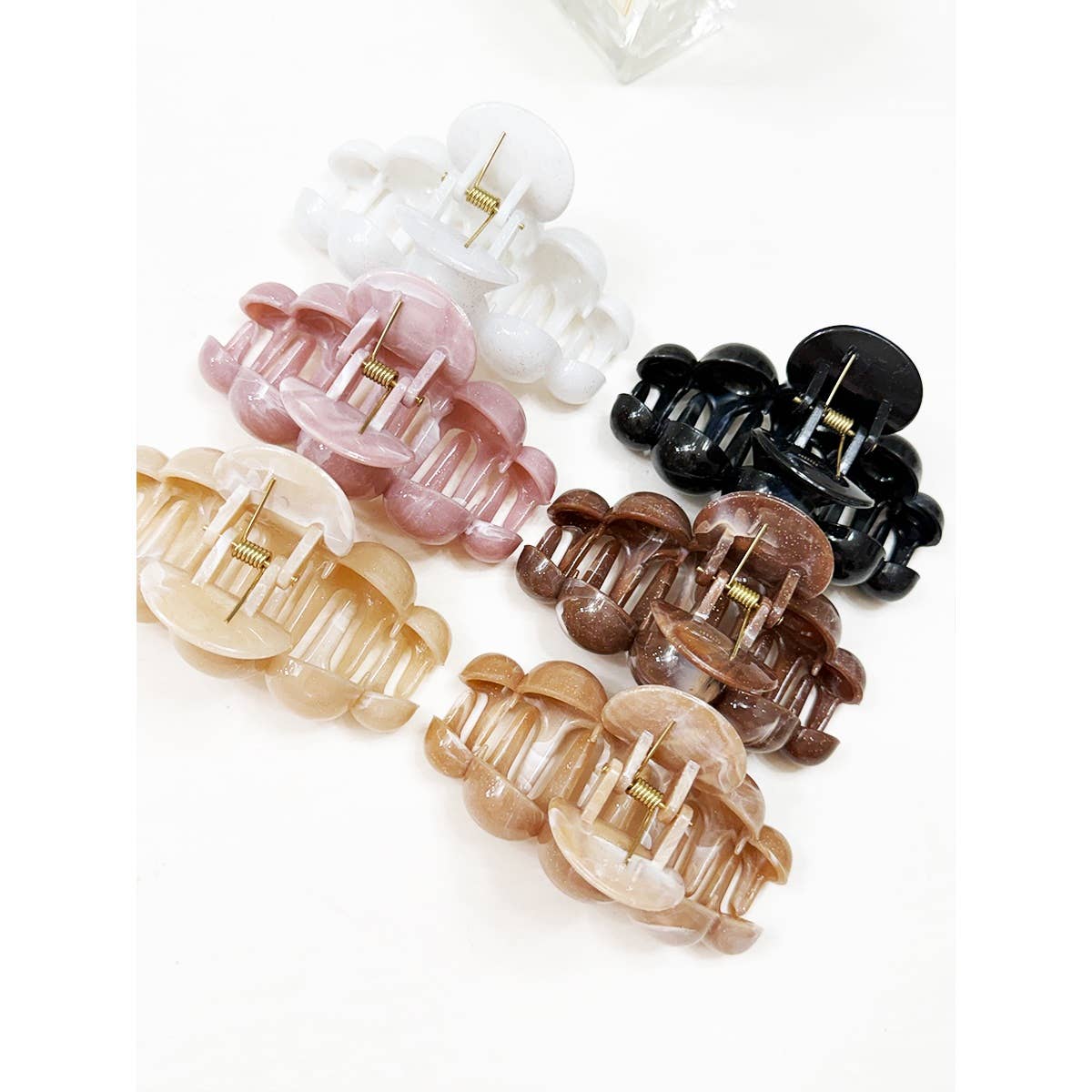 Six Large Marbled Hair Claws by Love and Repeat, in white, black, pink, brown, tan, and beige marbled colors, are arranged on a white surface in two rows of three.