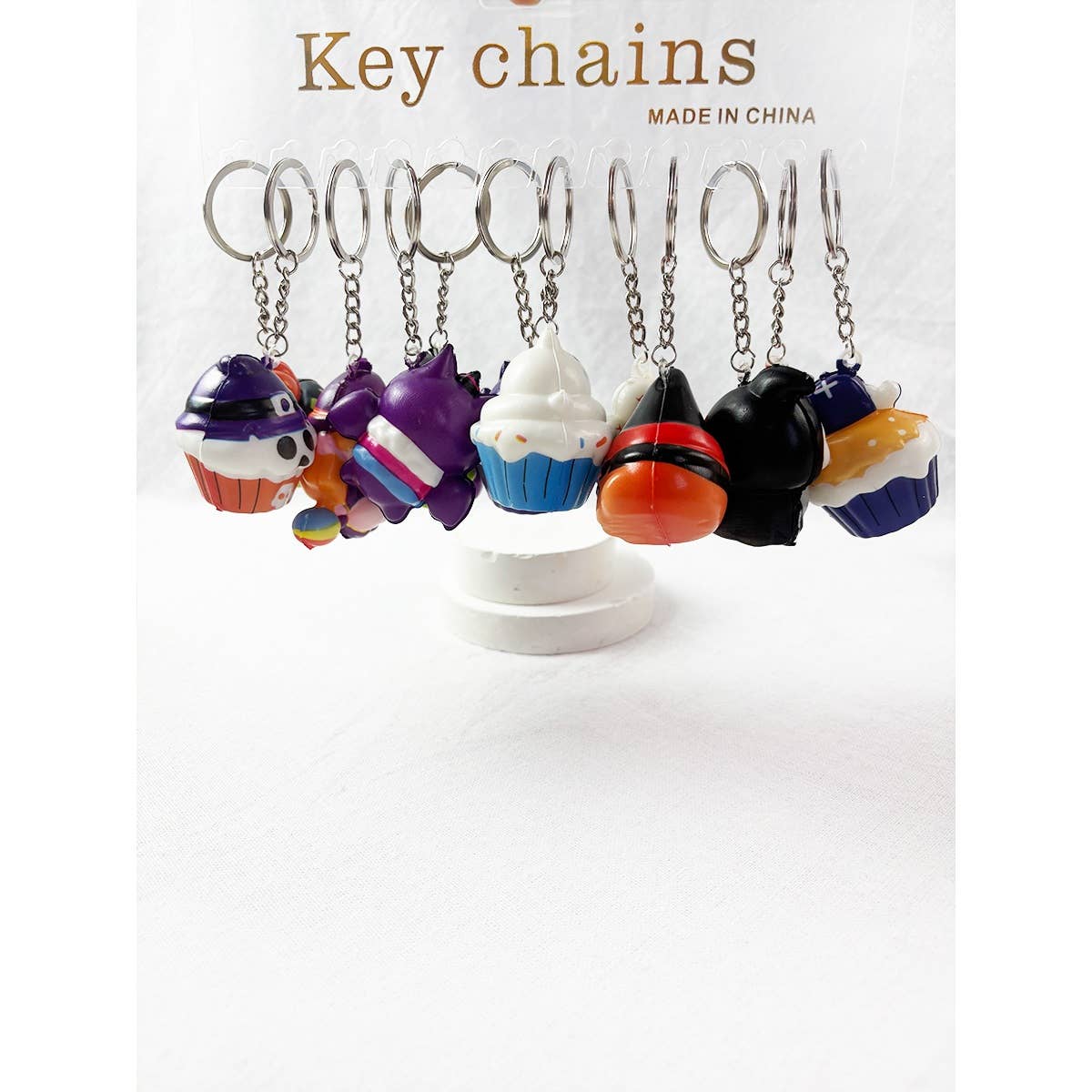 A display card holding several Halloween Squishy Keychain cupcake keychains.