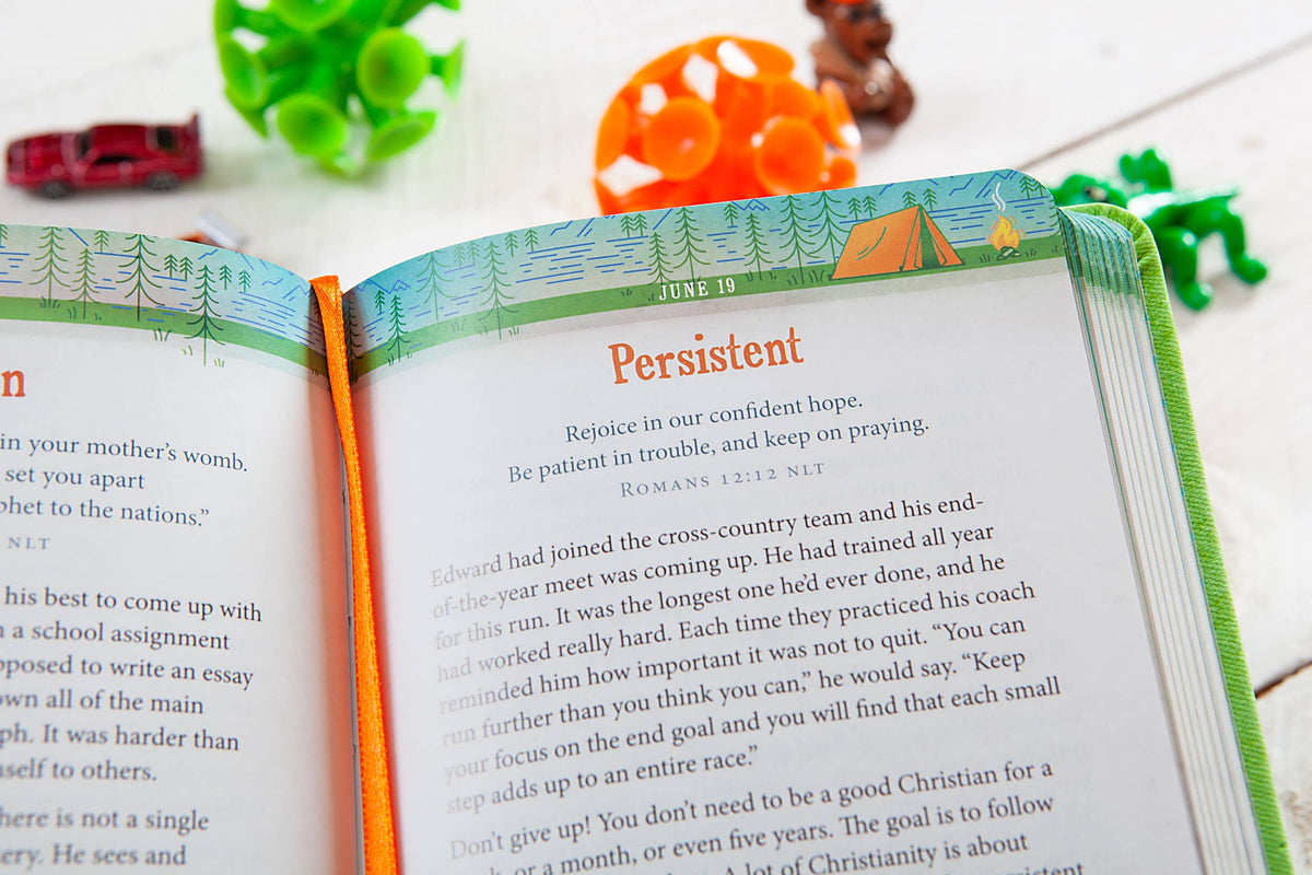 A copy of BroadStreet Publishing Group, LLC’s “A Daily Word for Boys Book” lies open, featuring persistent, decorative camping illustrations alongside green, orange, and red toy animals and vehicles scattered across a white wooden surface.