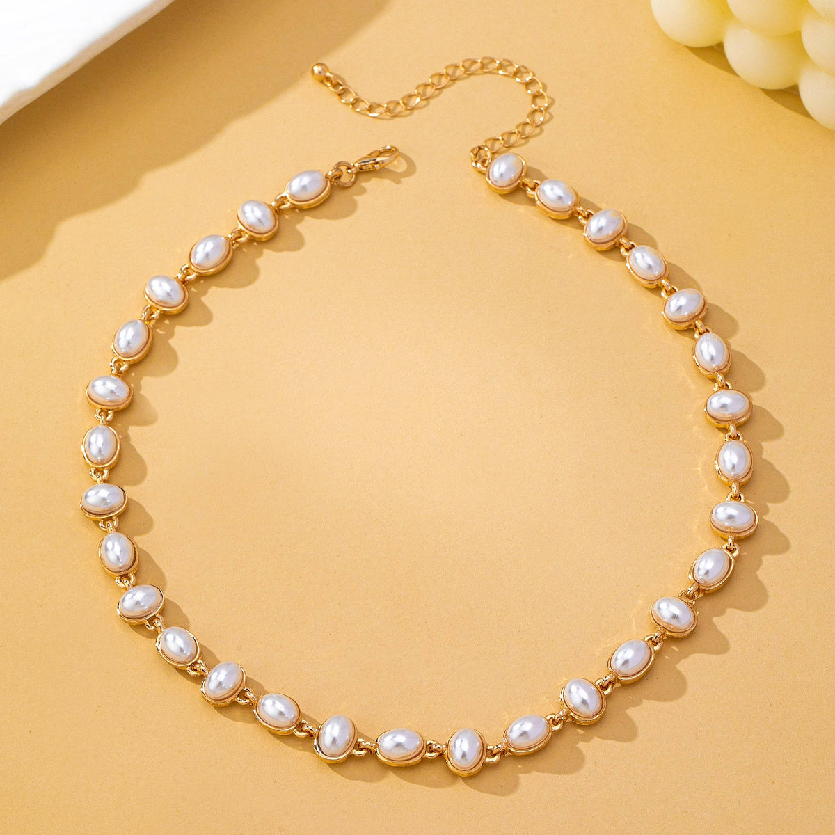 JOSSLYN by wall to wall Oval Pearl Link Necklace featuring a gold chain with oval-shaped white pearls as links and an adjustable clasp.