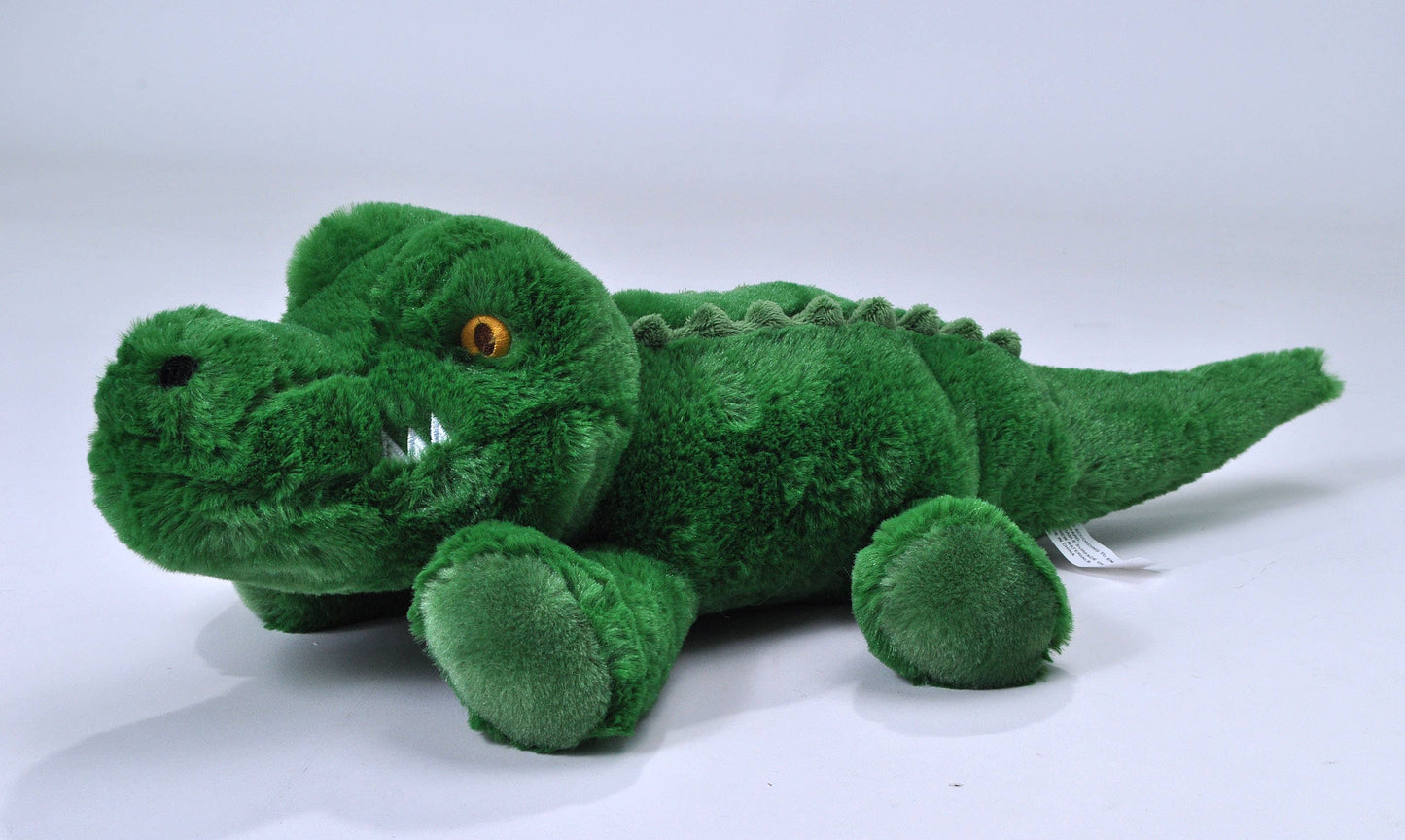 The Wild Republic Alligator Stuffed Animal is a soft, green plush toy featuring yellow eyes, white plush teeth, and textured ridges on its back, shown lying on a plain white surface.