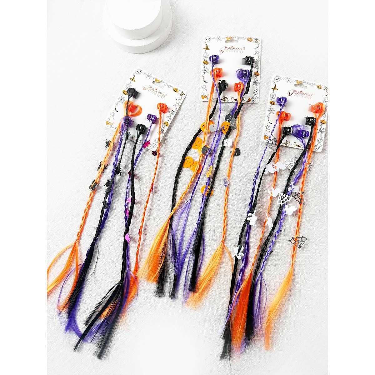 Love and Repeat Halloween Braid Hair Extension Clips featuring three sets of orange, purple, and black braided strands decorated with spider, pumpkin, and ghost charms.