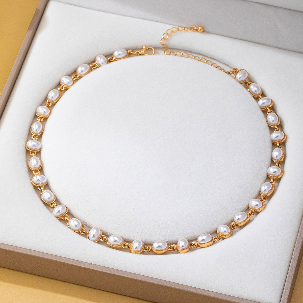 JOSSLYN by wall to wall Oval Pearl Link Necklace featuring a chain of oval pearls linked in gold frames, displayed in an open jewelry box.