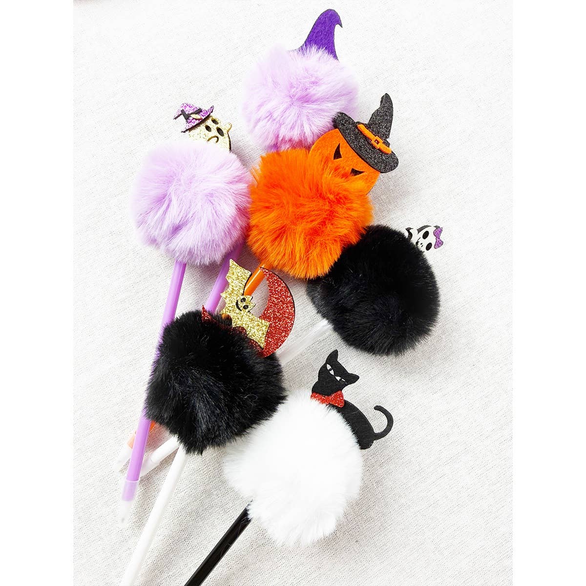 Love and Repeat Halloween Theme PomPom Pens: five pens topped with colorful faux fur pom-poms featuring Halloween-themed charms like a pumpkin, a cat, a ghost, a bat, and a witch’s hat.
