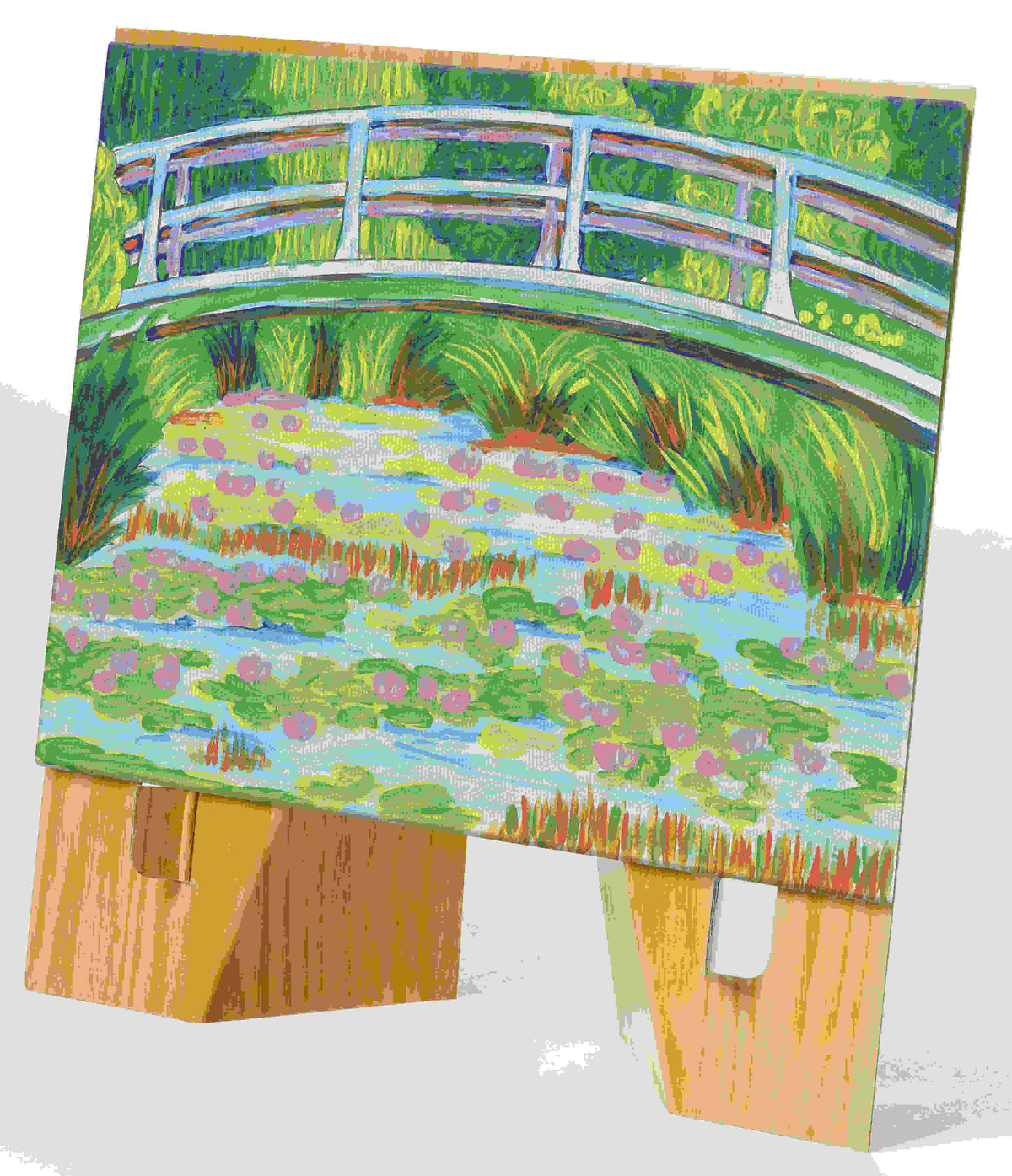 A small painting created with the Paint by Number Museum Series - The Japanese Footbridge by Faber-Castell / Creativity for Kids, inspired by Monet’s iconic scene. Displayed on a wooden stand, vivid greens, blues, and pinks sweep across the canvas to evoke a masterpiece in vibrant color.