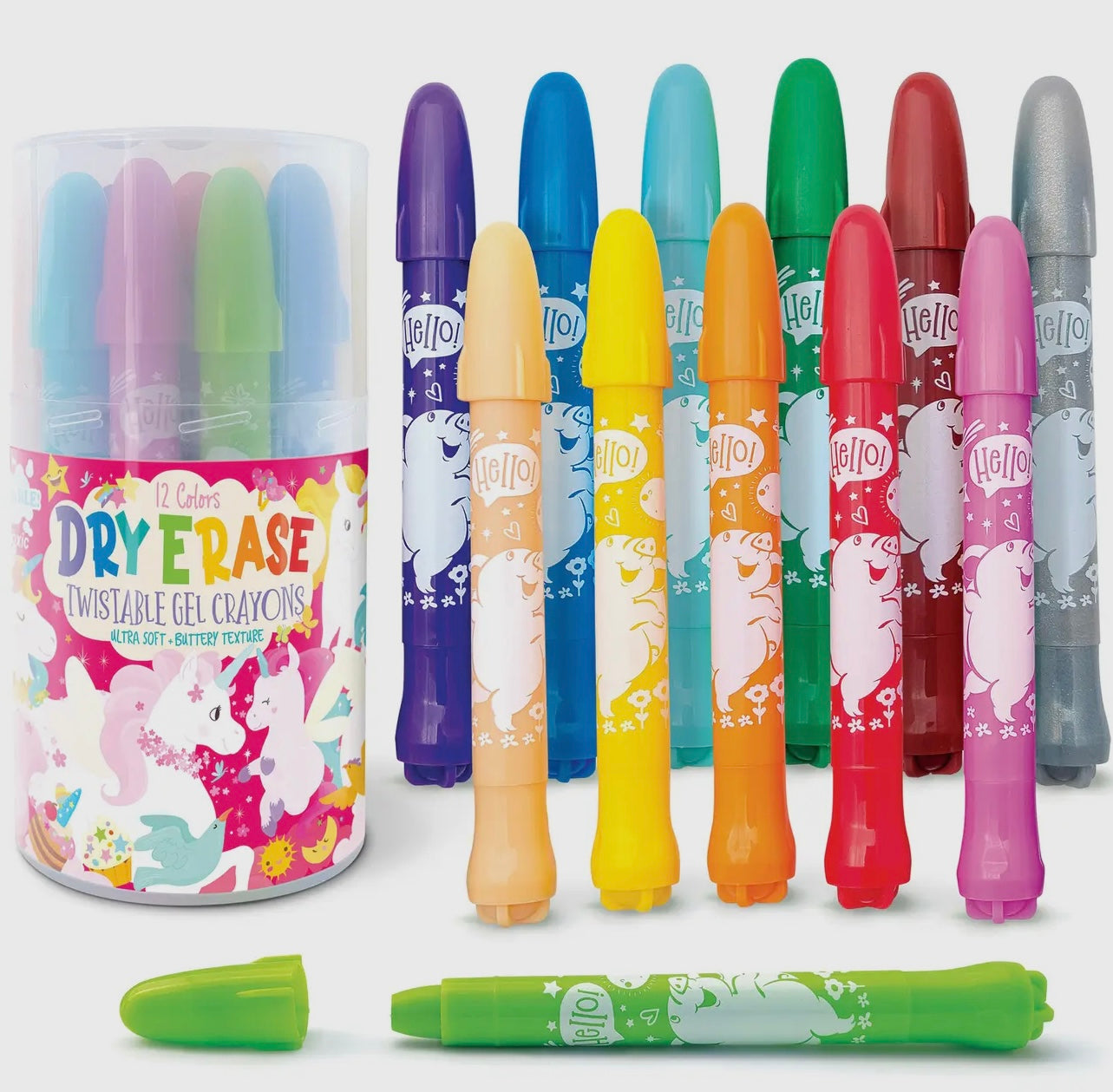 Twelve colorful Dry Erase Gel Crayons - Unicorn Fantasy by The Piggy Store stand upright beside their cylindrical container featuring playful unicorn graphics, with one green crayon lying horizontally in front.