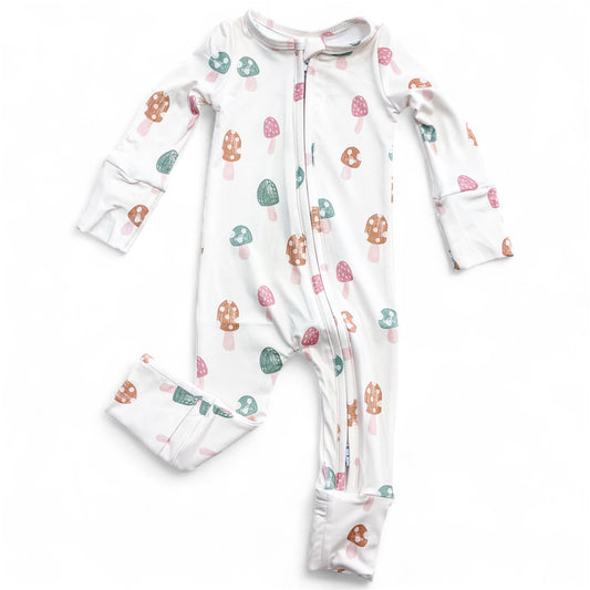 The Tiny Tot Bundles Mushroom Meadow Zippy is a white baby onesie with long sleeves and legs, featuring pink, green, and brown mushroom patterns, a front zipper, and cuffed wrists and ankles.