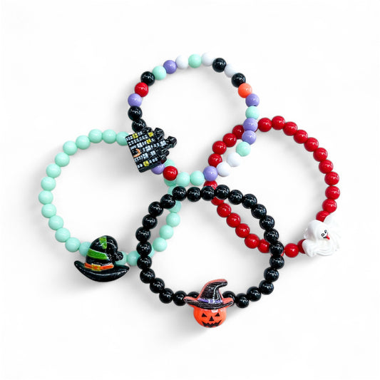 Four Spooky Bead Bracelet elastic bead bracelets featuring Halloween-themed charms, including a haunted house, a witchs hat, a ghost, and a jack-o-lantern.