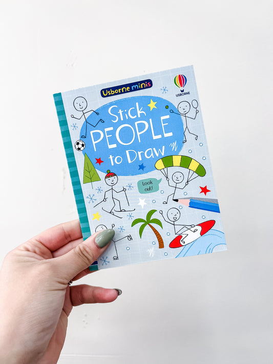 A hand holds a small book titled "Usborne Minis Activities On The Go" by HarperCollins, with cartoon stick figures playing sports and doing activities like surfing and paragliding on the cover.